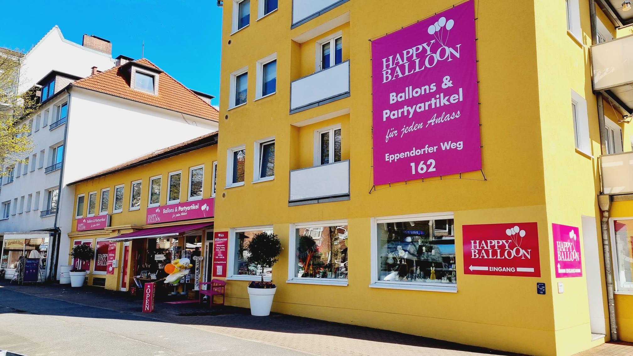 Happy Balloon am Eppendorfer Weg: gelbe Fassade mit pinker Beschilderung und Ladeneingang